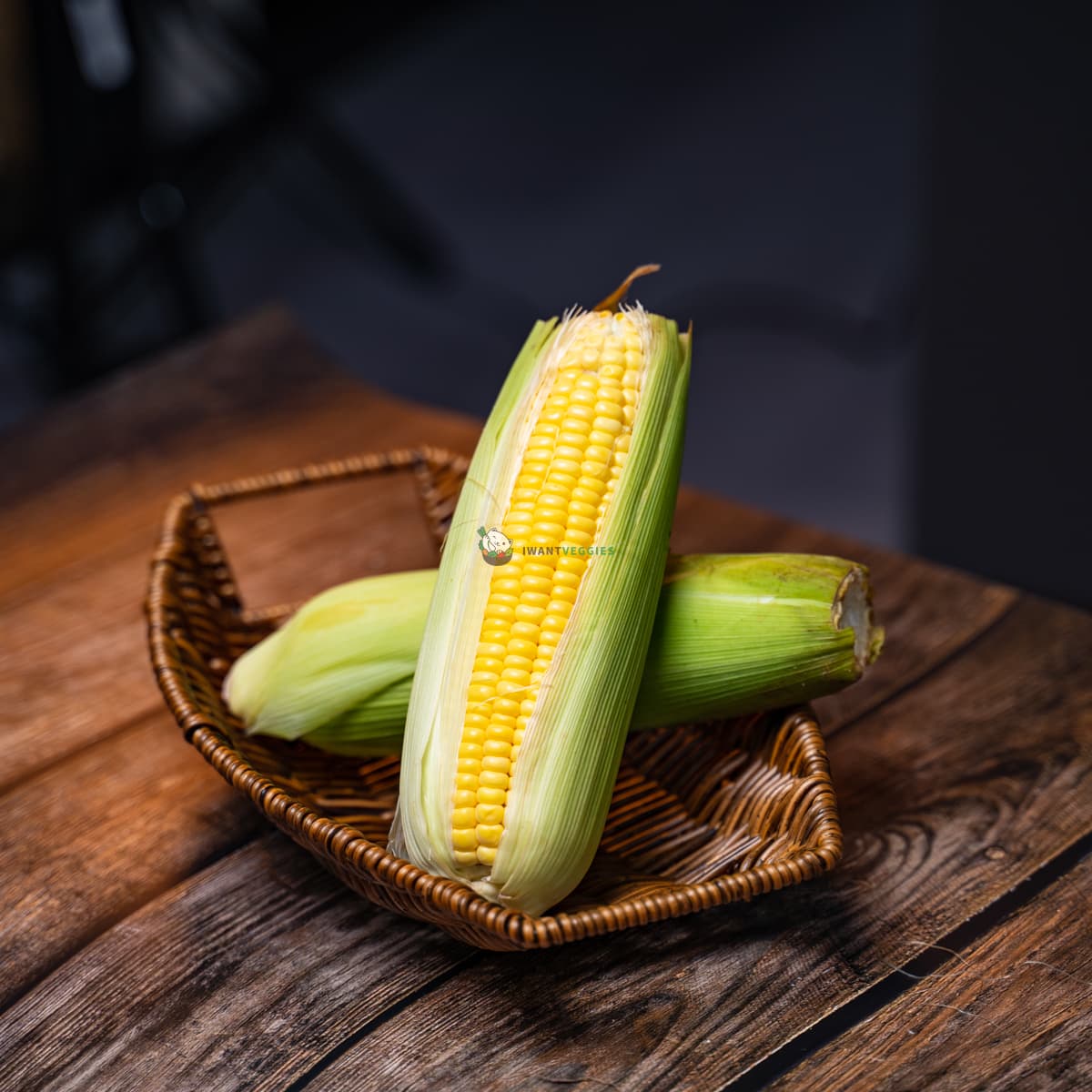 Two yellow sweet corn on a wooden basket - fresh, vibrant, and ready to be enjoyed. A perfect summer treat!