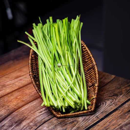 Qing long choy laid on basket & wood surface - long, slender leaves with thick stems & green color. A popular Asian leafy vegetable