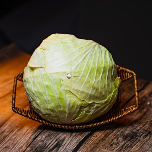 A round cabbage on a basket, on wooden surface. Fresh and vibrant green leaves. A healthy and versatile vegetable