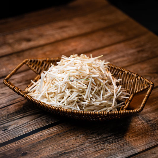 Silver beans in a basket on wood. Shiny and smooth with pointed ends.