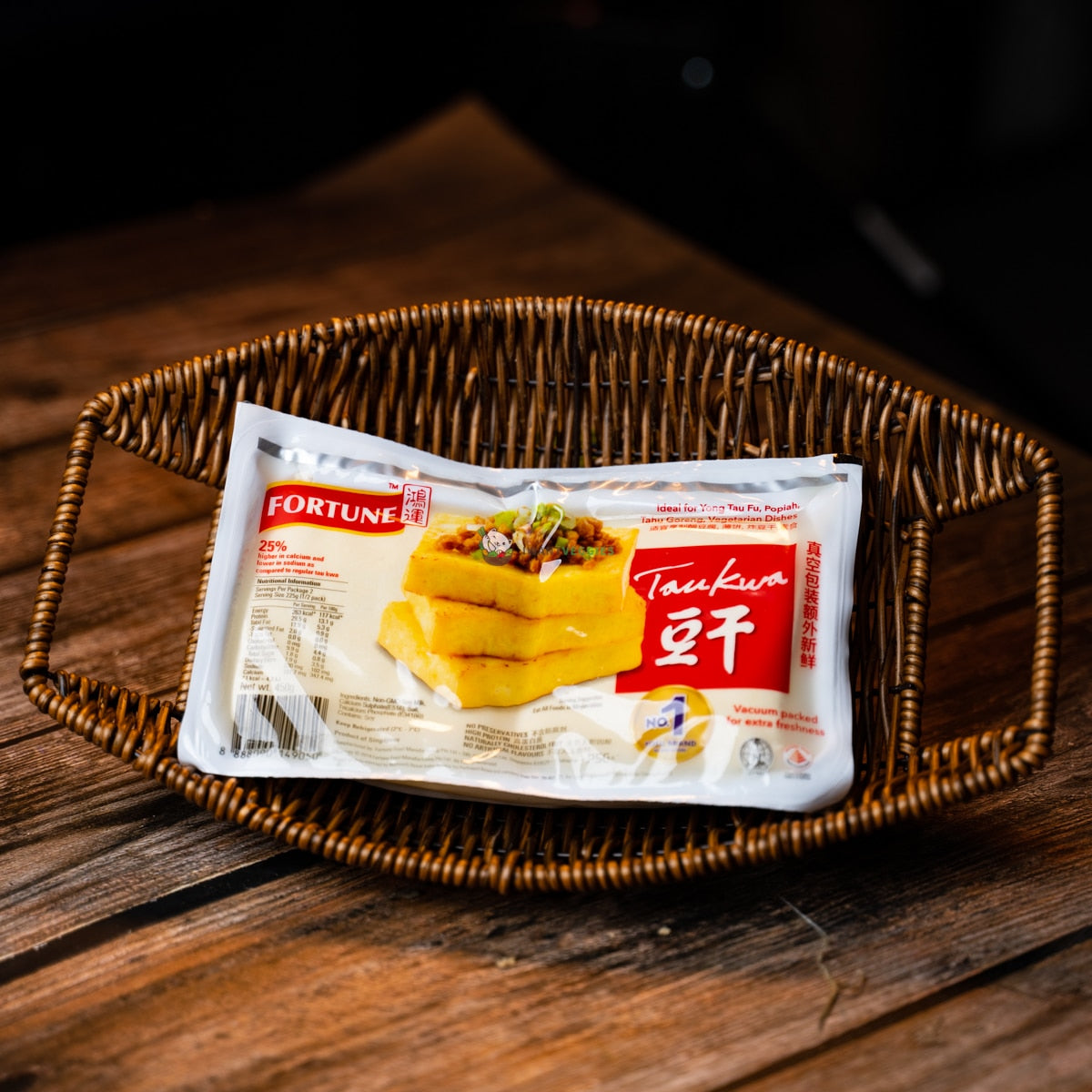 A packet of Fortune tau kwa on a wooden basket. It is a firm tau kwa with a fried and rough texture. It is ready to eat, serve warm or microwave.