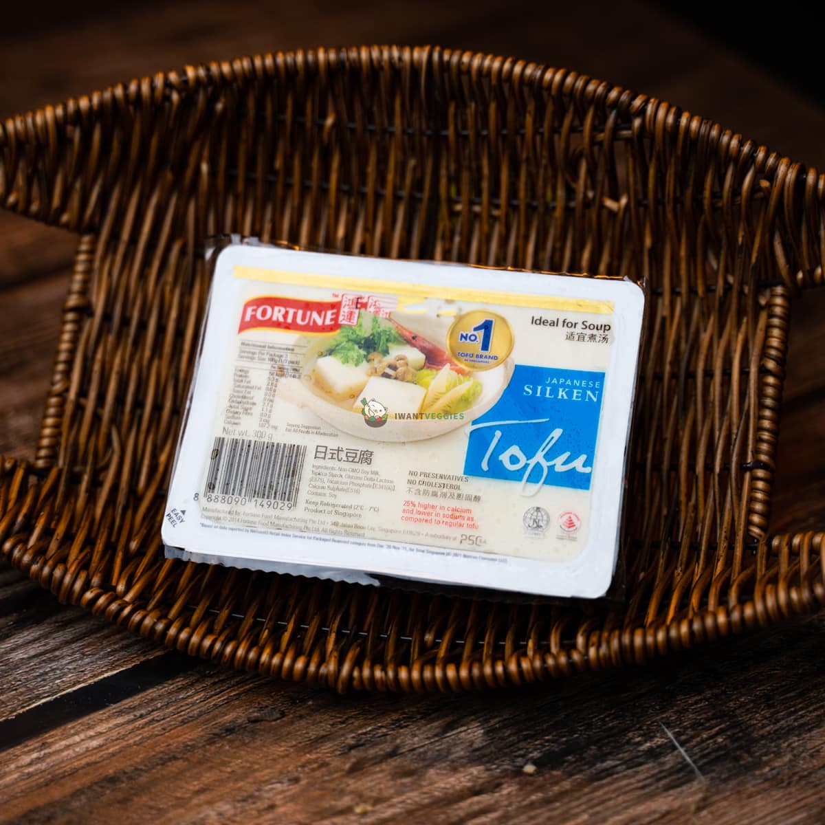 A packet of Fortune silken tofu on a wooden basket. Soft, creamy, and white.