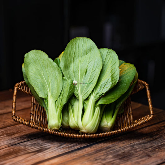 A bunch of sio peh chye (Chinese spinach) on a wooden basket. The leaves are dark green and have a slightly bitter taste. 